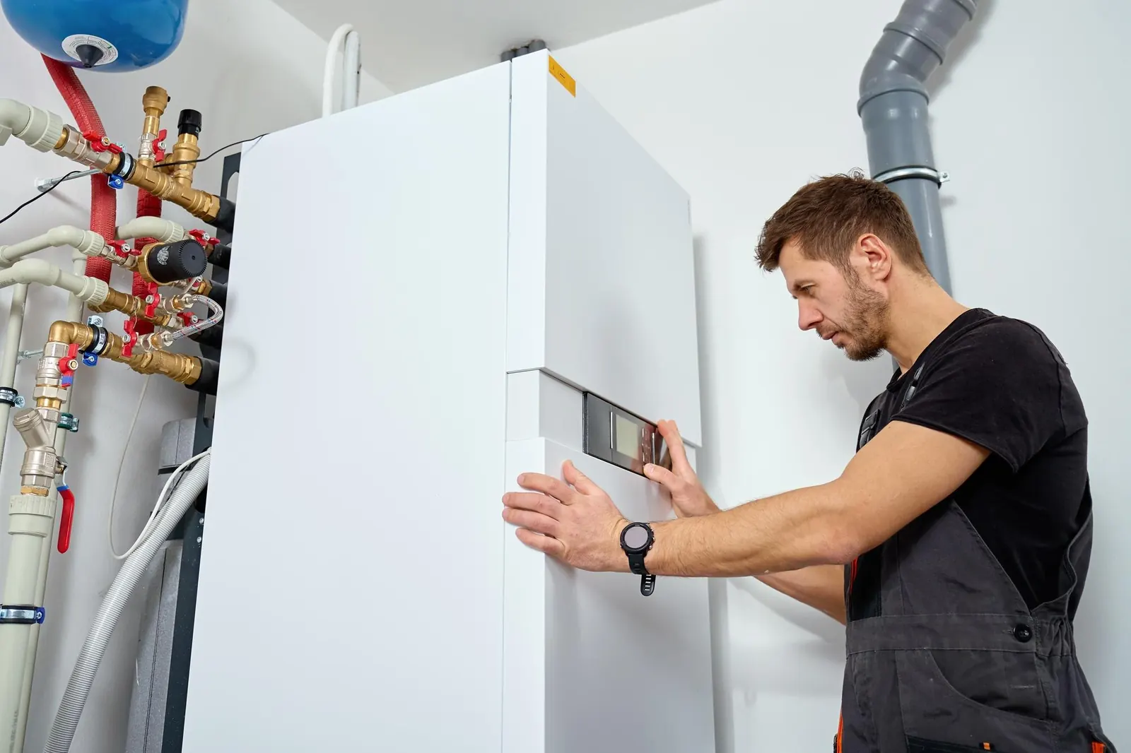 Technicien installant un système de pompe à chaleur avec tuyaux